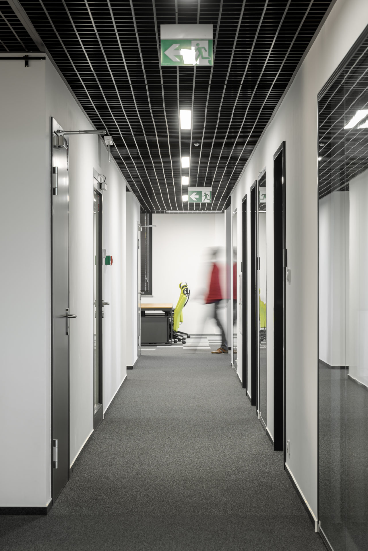 Minimalistyczny, monochromatyczny korytarz biura.